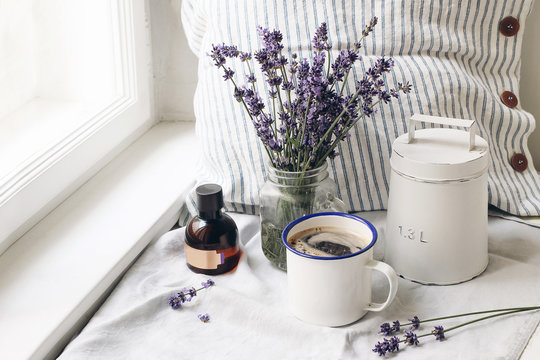 French Summer Still Life. Cup Of Coffee, Lavender Flowers Bouquet, Essence Oil Bottle On Windowsill. Feminine Styled Stock Photo, Floral Composition With Lavandula Officinalis Herbs. Rustic Scene.