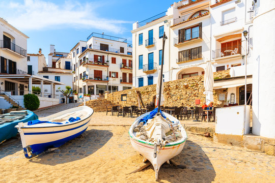 Traditional fishing boats on beach in Calella de Palafrugell, scenic village with white houses and sandy beach with clear blue water, Costa Brava, Catalonia, Spain