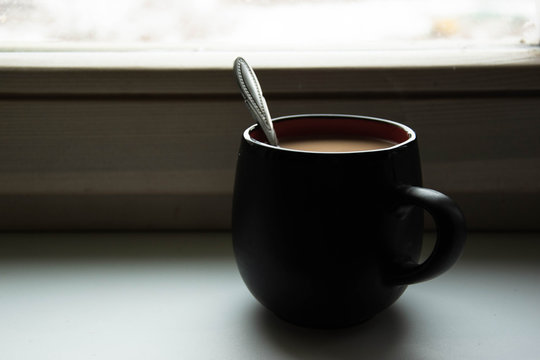 The cup of coffee on a windoww sill