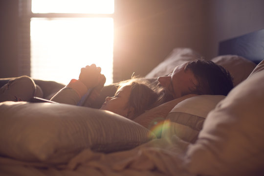 Parent and child share a lazy morning in beautiful, dreamy light.