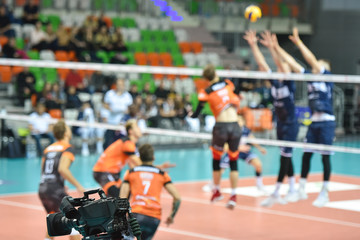 TV camera directed to the end line of the court in background volleyball match