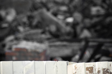 Corrugated metal fence on the background of the dismantled building
