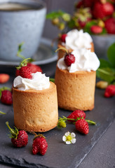 Biscuit cakes filled with wrapped cream and strawberries. Sweet cup cake dessert 