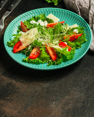 salad with tomato, lettuce, arugula, spinach and other leaves. food background. top