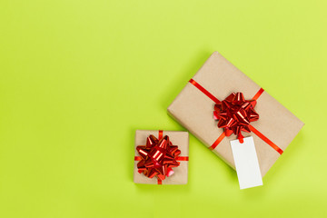 beautiful gift boxes wrapped in paper with a red ribbon and a bow on a green surface. Top view