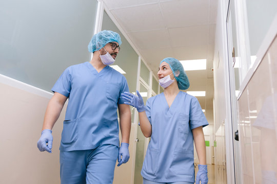 fellow surgeons man and woman chat while walking towards the operating theater