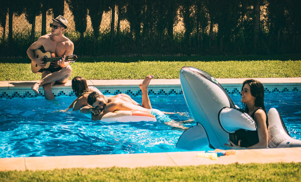 Men and women relaxing in poolside