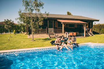 Young friends having drinks in pool