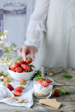 Faceless chef using fresh juicy tasty strawberries while preparing creamy sweet dessert