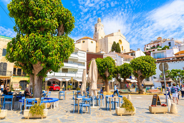 CADAQUES VILLAGE, SPAIN - JUN 4, 2019: Church square with restaurants in Cadaques port, Costa...