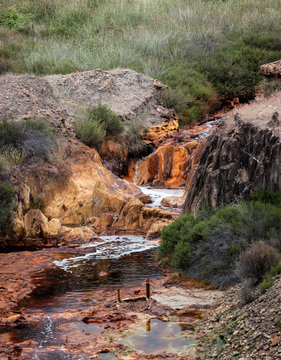 Small red river waterfall of rocky landscape in Riotinto, Huelva
