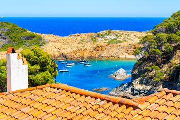 View of  Sa Tuna sea bay with orange tile roof in foreground, Costa Brava, Spain