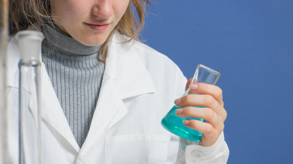 Girl chemist biologist with test tubes, close up.