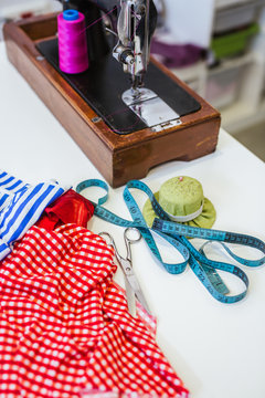 Teenage girl student practicing sewing on modern machine in cozy workshop