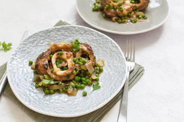 Ossobuco alla milanese - Lombard cuisine of cross-cut veal shanks, made with white wine, broth and green peas.