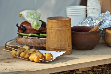 Potatoes baked on a grill on a wooden table. Natural food in wooden dishes.