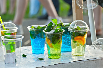 Multicolored fruit drinks close-up. Non-alcoholic drinks in plastic cups at the festival. Cocktails...