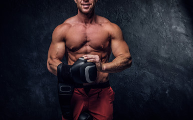 Muscular man is prepaired for boxing sparring, he is wearing his gloves and doing some warm up.