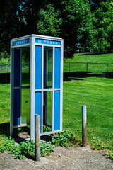 Vintage phone booth in front of a freshly cut lawn