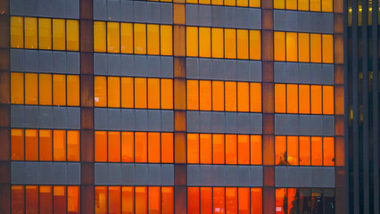 CLOSE UP: Burnt orange morning sky reflects off the windows of skyscrapers.