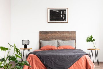 Bright natural interior with wooden bed and coral linen sheets
