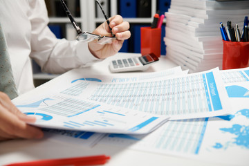 Businessman working and calculating, reads and writes reports. Office employee, table closeup. Business financial accounting concept.
