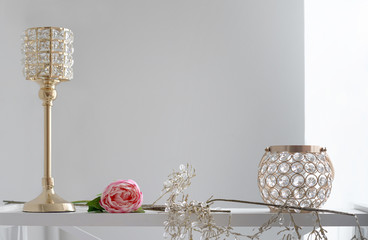 Golden and crystal candle holders - Golden home accessories on wooden shelf