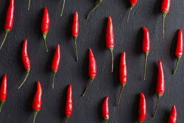 Red Hot Chili Peppers On Black Dark Background on Black Table. A Lot of Red Chilli Peppers. Copy...