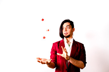 Young magician throwing dice to the air to look for luck.