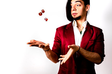 Young magician throwing dice to the air to look for luck.