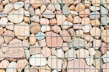 Textured background, pebbles behind steel bars