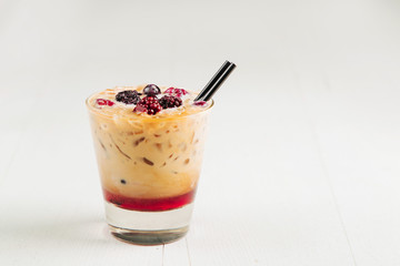 Iced coffee with milk,  syrup and berries. Fresh summer drink.