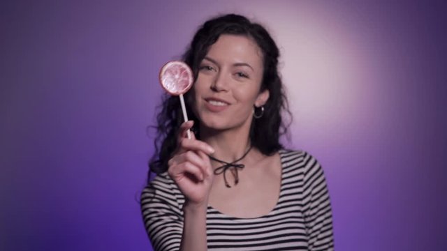 studio shot of dark hair woman with delicious candy