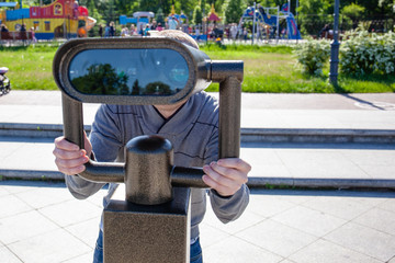 guy looks through the city binoculars
