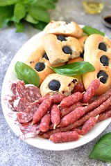 Homemade Italian bread focaccia with dried sausages and basil.