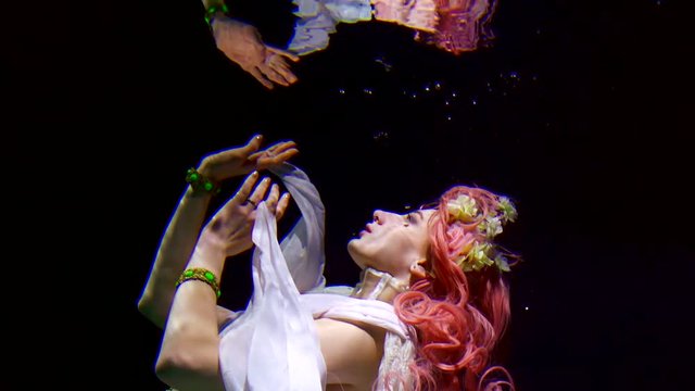 Floating model posing underwater in a beautiful dress.