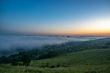 Foggy morning in the village on the river bank