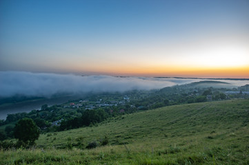 Foggy morning in the village on the river bank
