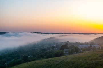Foggy morning in the village on the river bank