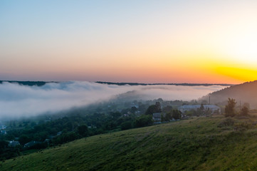 Foggy morning in the village on the river bank
