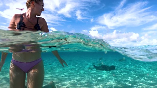 woman at exuma island with stingrays in the water
