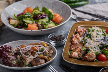 Healthy fruit platter, strawberries raspberries oranges plums apples kiwis grapes blueberries on the dark grey wooden table, top view, close up, selective focus