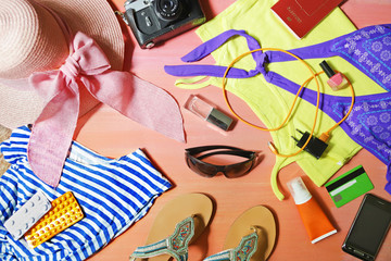 colorful summer female fashion outfit flat-lay. Top view. Summer fashion, holiday, striped shirt, swimsuit, camera, medications