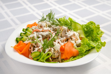 salad of boiled beef, champignons, carrots, pickled cucumbers, onions and lettuce seasoned with mayonnaise