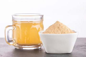 Maca root health drink in a glass with powdered - Lepidium meyenii. White background