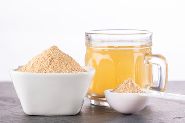 Maca root health drink in a glass with powdered - Lepidium meyenii. White background