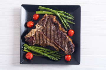 Grilled T-bone steak with asparagus and cherry tomatoes