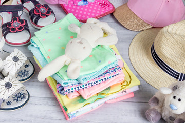 Summer clothes and shoes for a little girl with toys.