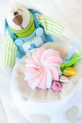 Fototapeta na wymiar Handmade toy. Doll of textiles, fabrics and yarn. Rabbit and cake sewn by hand. Homework.
