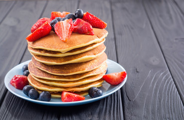 Tasty pancakes with blueberry and strawberry